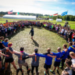 A large group of people stand in a circle.
